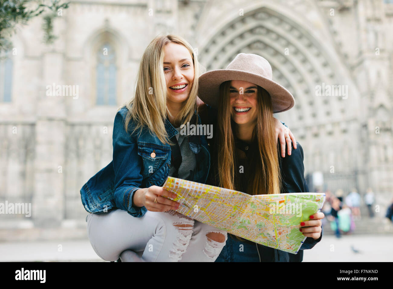 Spain, Barcelona, two happy young women reading map Stock Photo