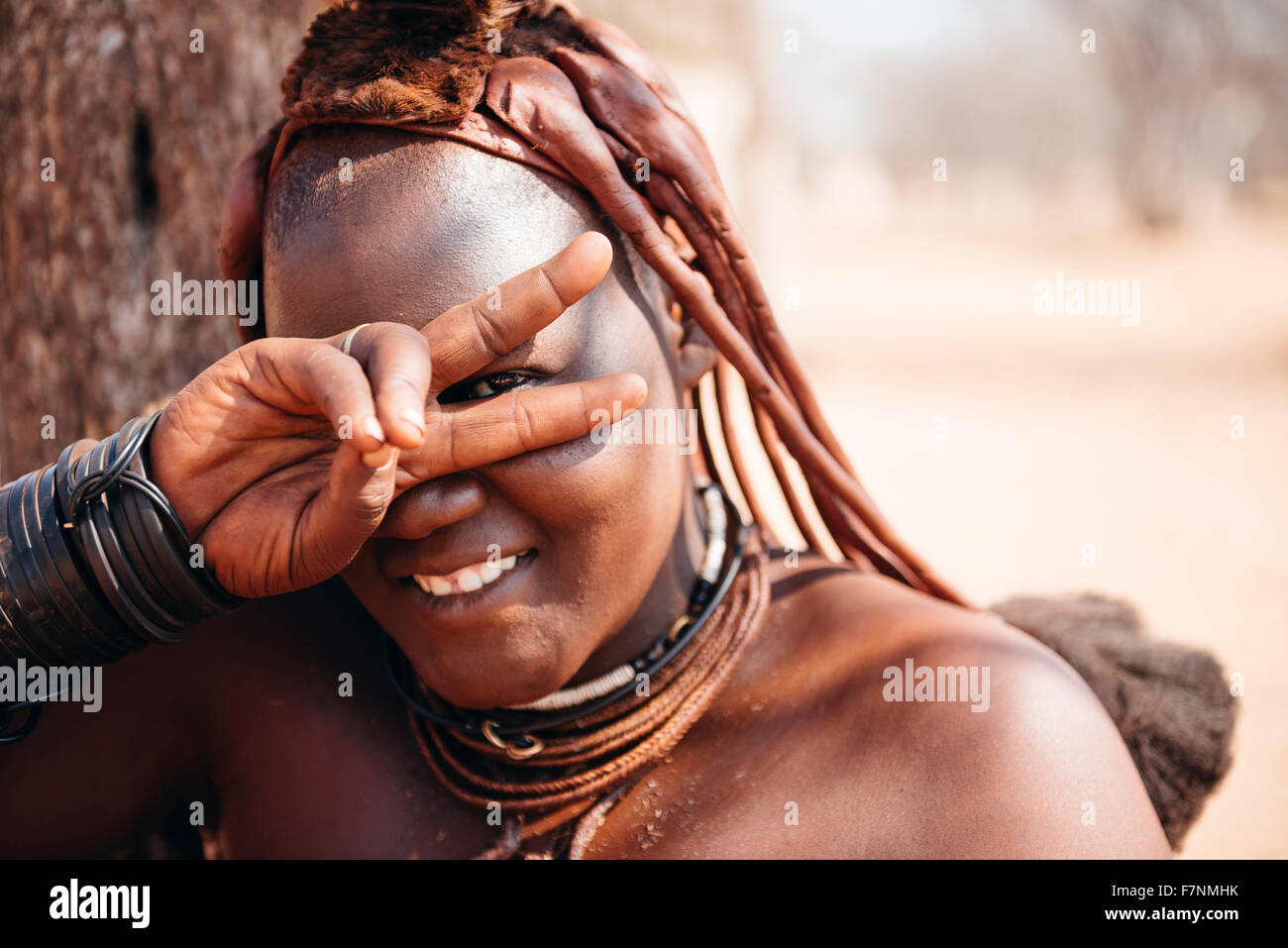 Namibia, Damaraland, portrait of smiling Himba woman making victory sign Stock Photo