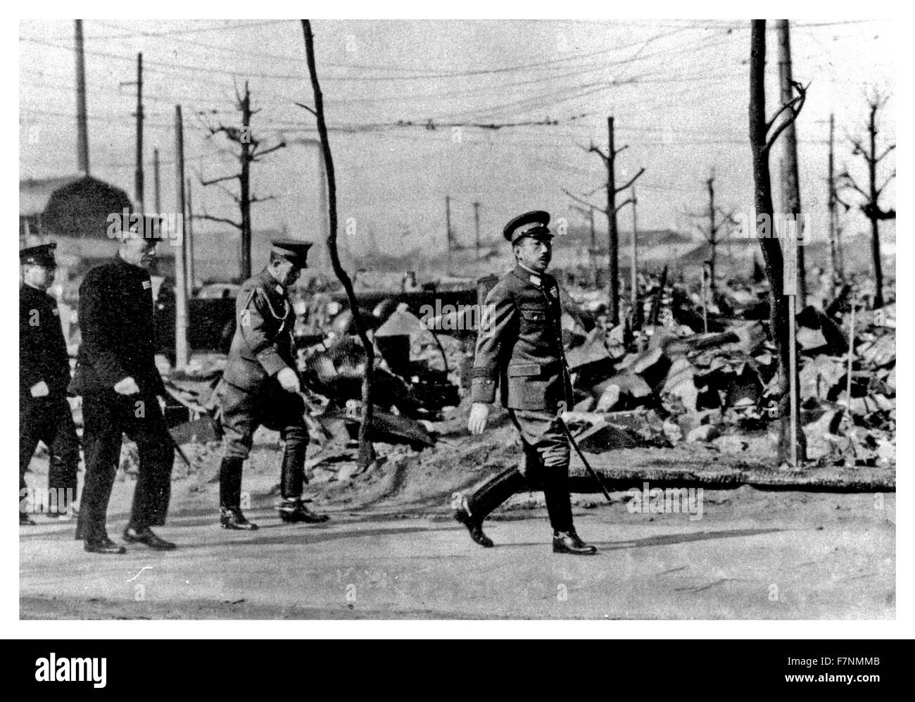 1945 Japanese Emperor Hirohito walks through the ruins of Tokyo following US air Force bombing in the later months of World war two. Stock Photo