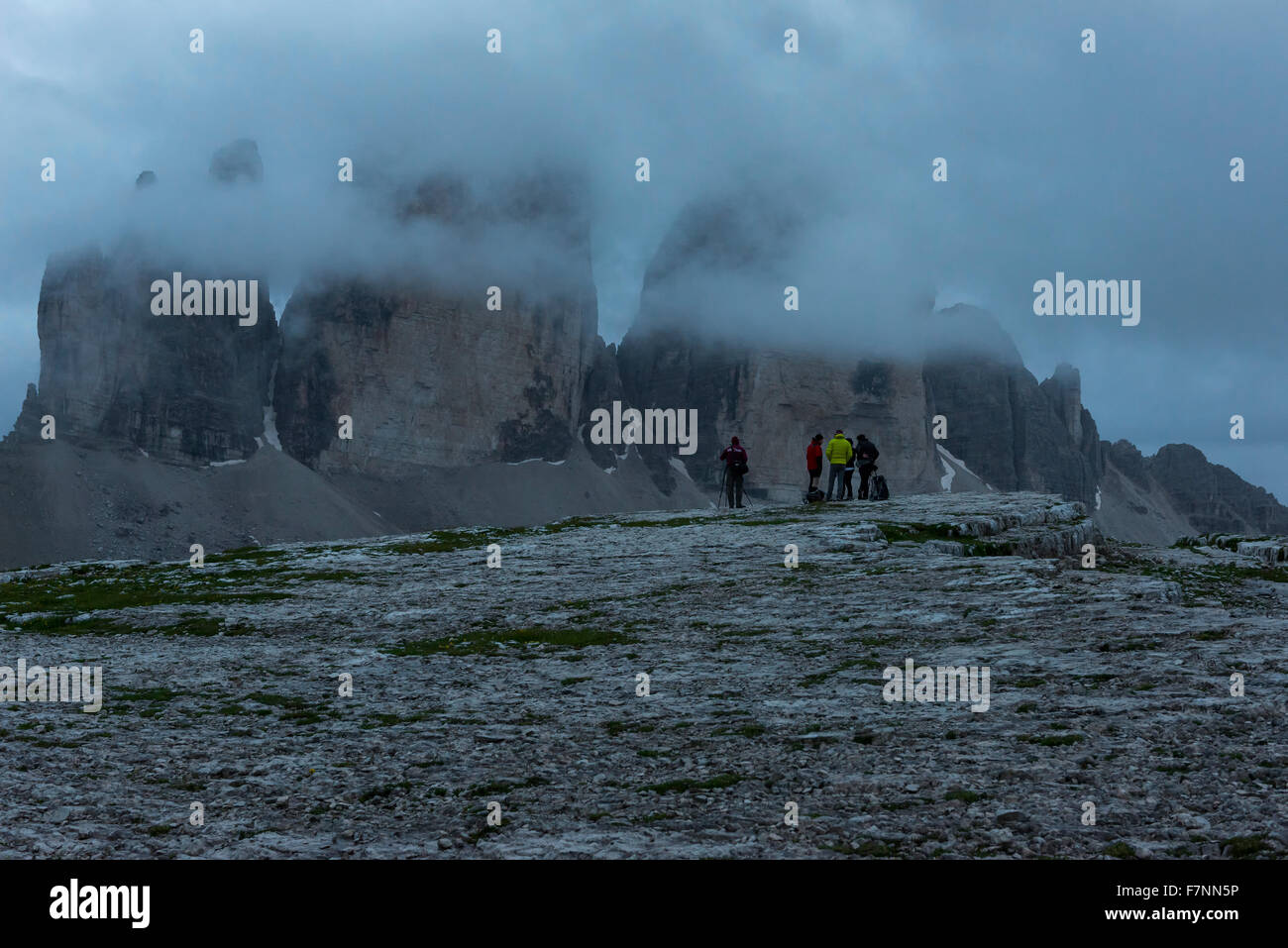 Italy, Alto Adige, Dolomites, group of five hikers in front of Tre Cime di Lavaredo on a cloudy day Stock Photo