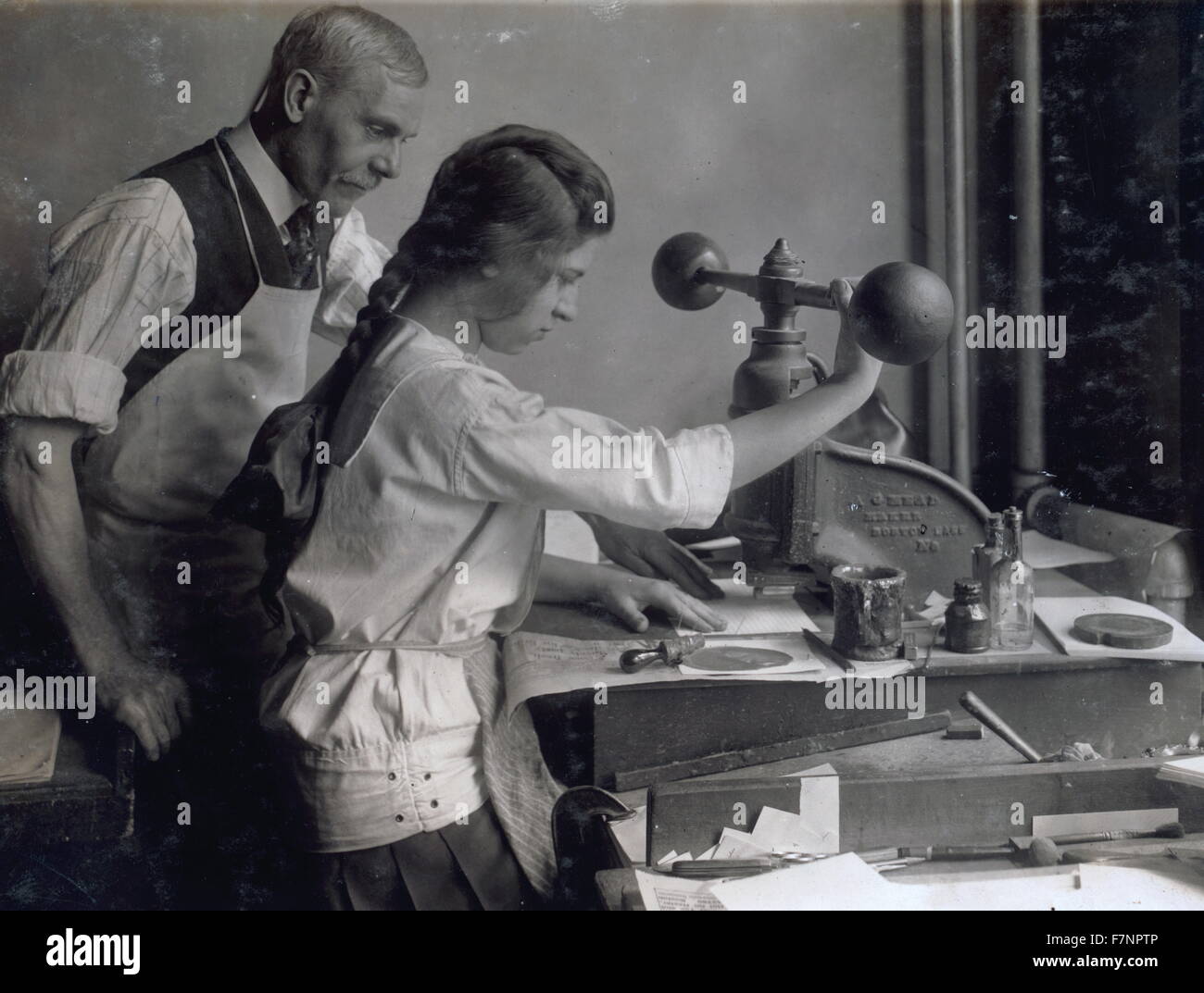Embossing shop of Harry C. Taylor, 61 Court Street. 15-year old girl at embossing machine. In Boston, Massachusetts. Stock Photo