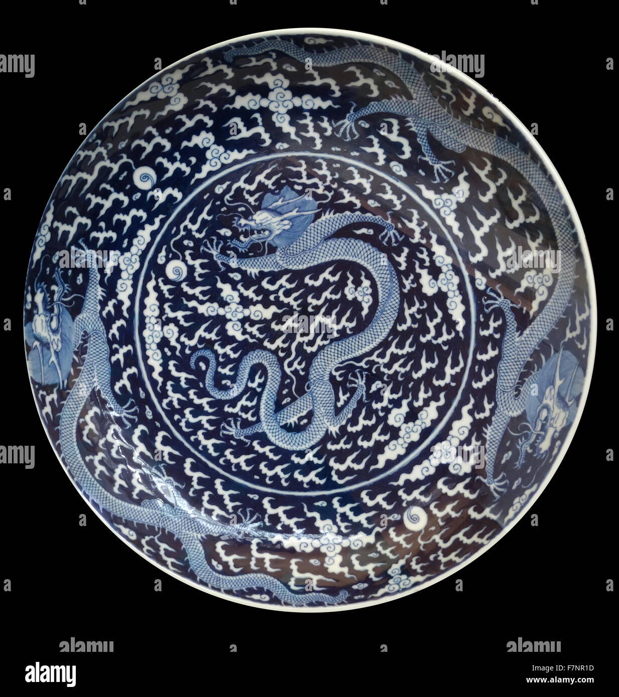 Blue and white porcelain charger from the Qing Dynasty, depicting a dragon. Dated 1875 Stock Photo