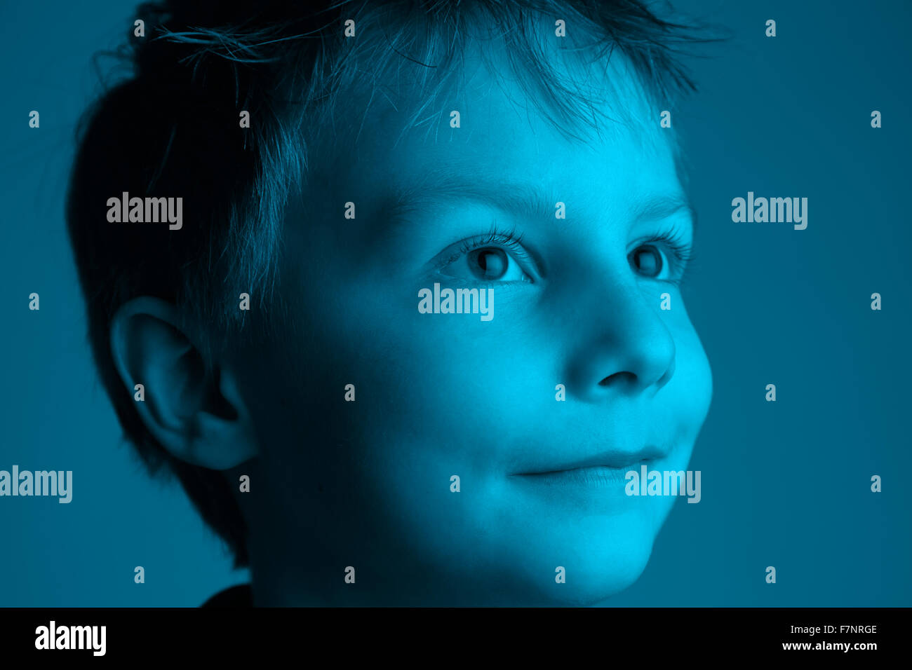 Big expectation - big eyes: eight year old boy looking towards the light Stock Photo