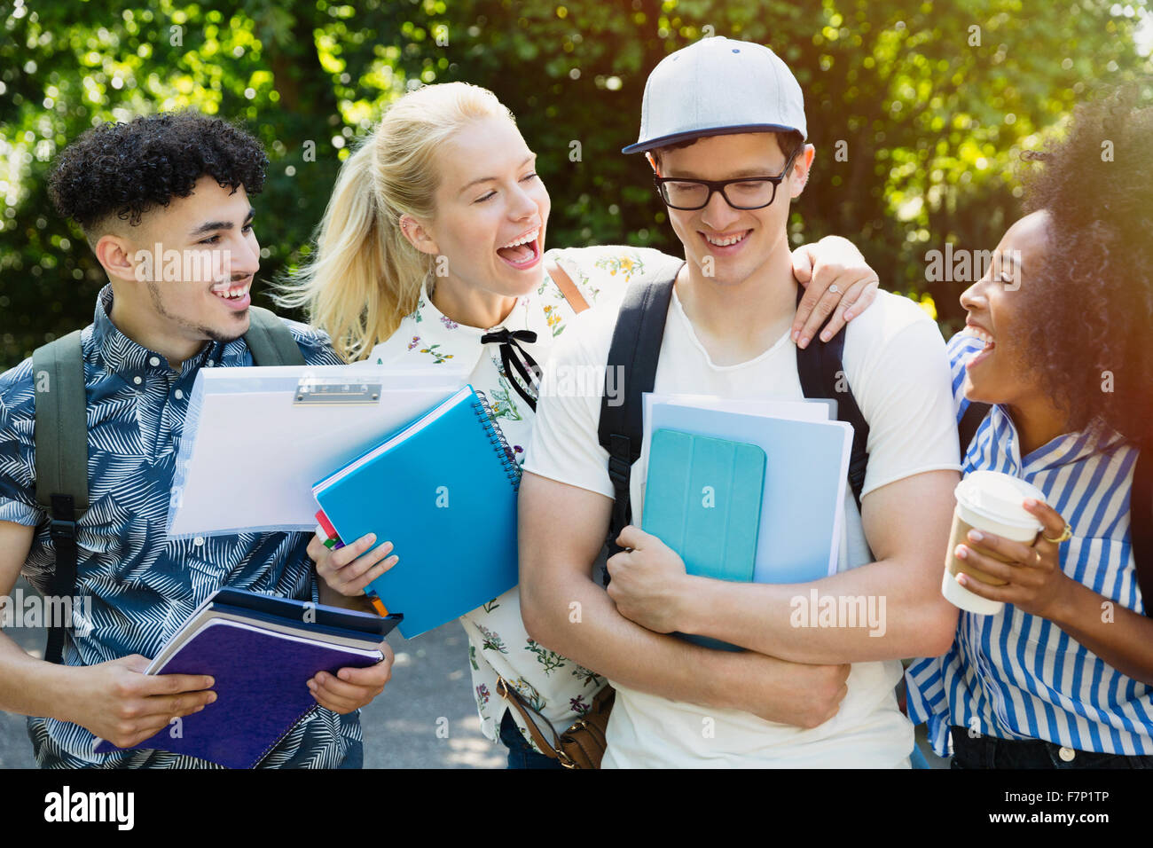 Enthusiastic college students joking friend outside Stock Photo