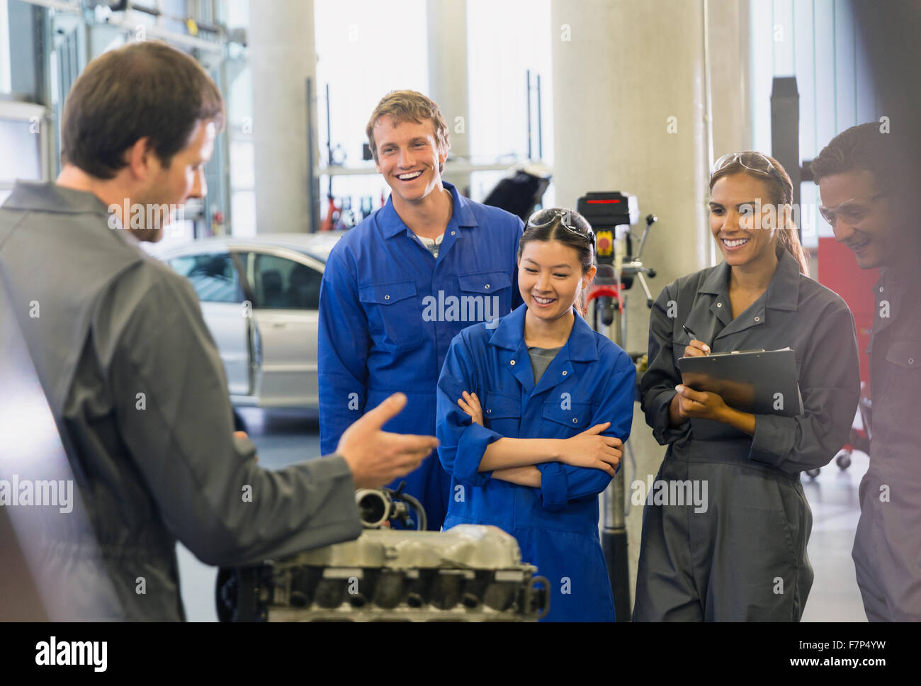 Mechanics discussing car engine in auto repair shop Stock Photo