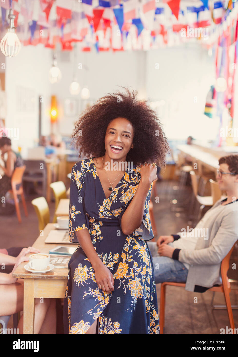 Portrait enthusiastic woman with afro in cafe Stock Photo