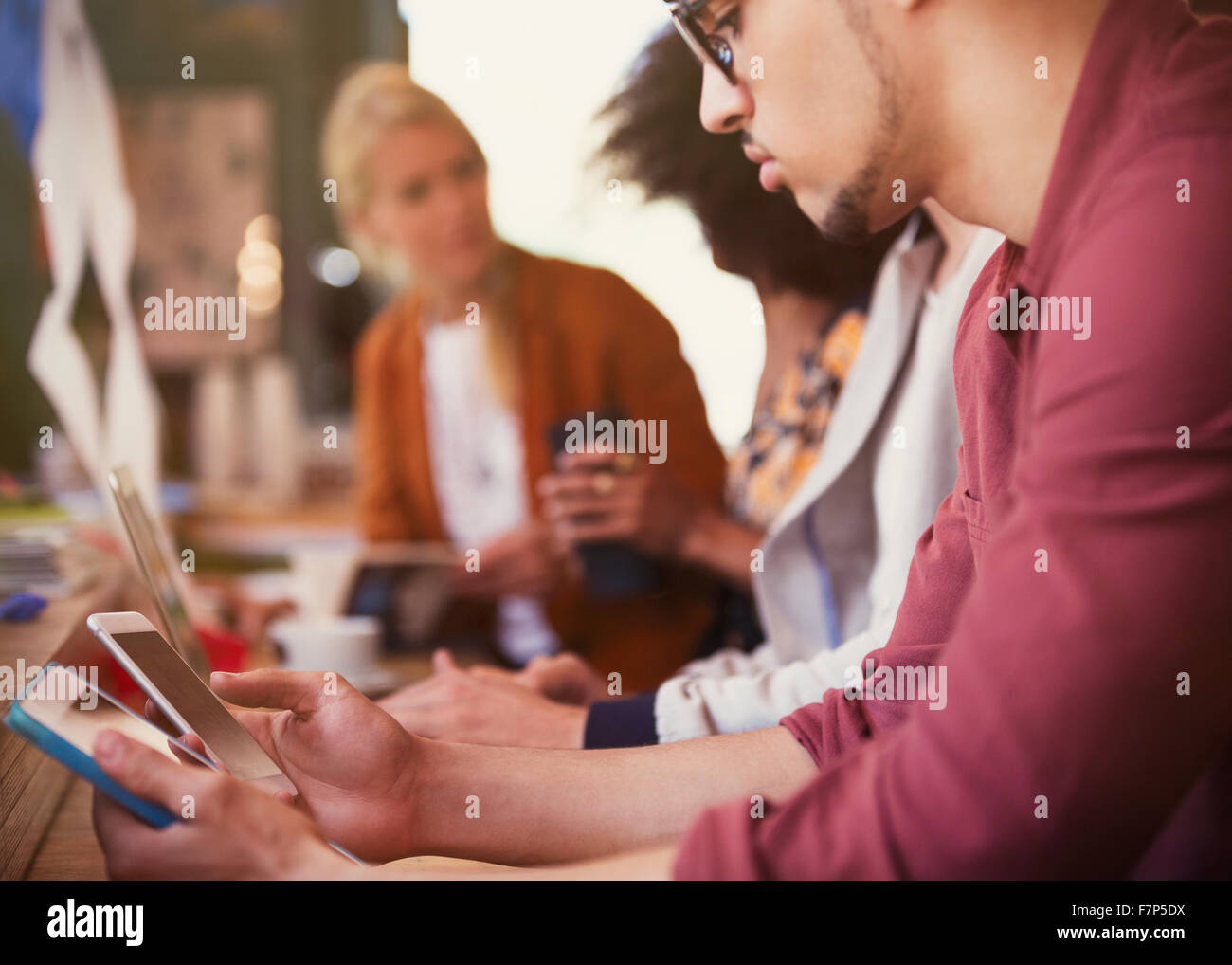 Man using digital tablet and cell phone in cafe Stock Photo