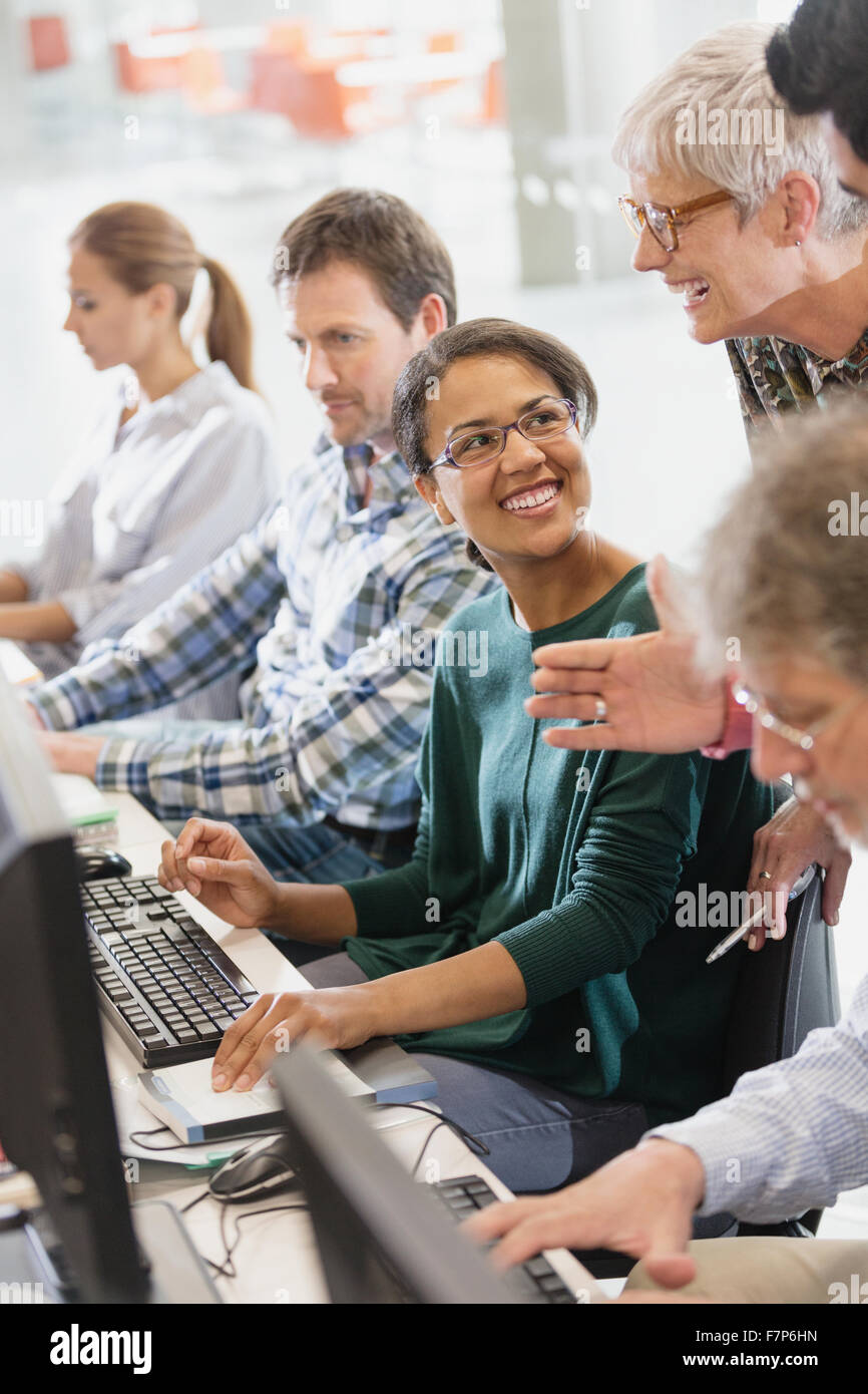 Students talking at computers in adult education classroom Stock Photo