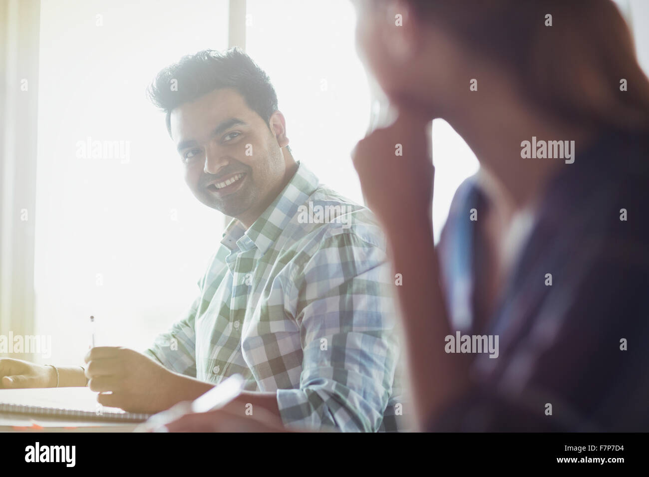 Smiling students talking in adult education classroom Stock Photo