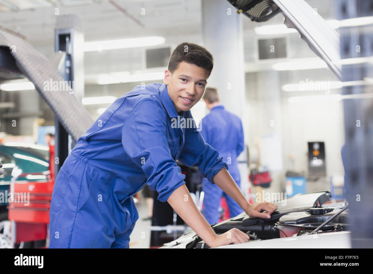 Portrait confident mechanic leaning over car engine in auto repair shop Stock Photo