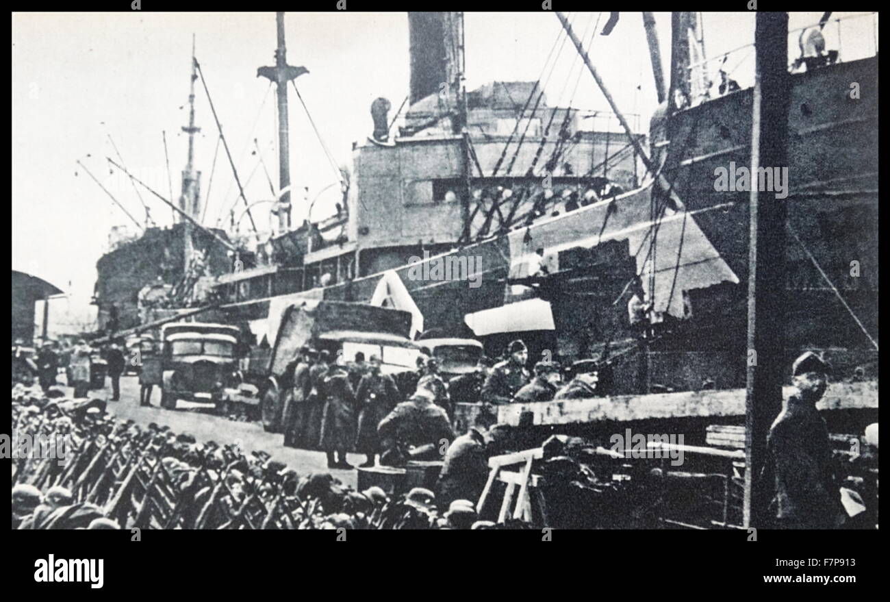 The German Baltic port troops carring military weapons and ammunition on board the transport ships cargo. Taken c1940 Stock Photo