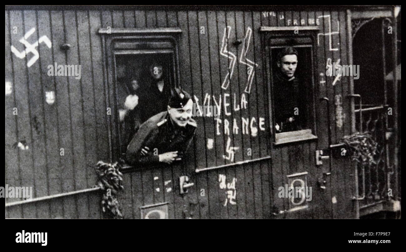 French volunteers to the Waffen SS are shown departing on a train towards their garrison (Fort/camp). The train is heavily graffitied with Nazi propaganda, including swastikas and SS logos. Dated 1940. Stock Photo