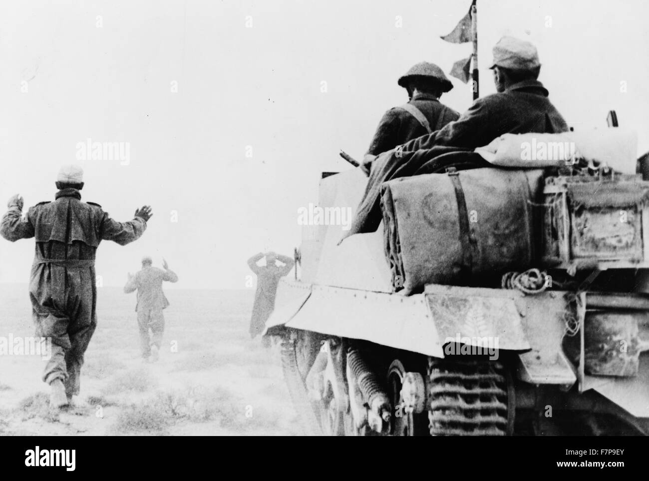 Photographic print of a Second World War German infantry surrendering to men of New Zealand Bren carrier unit. A wounded prisoner can be seen riding in the back of the carrier. Dated 1942 Stock Photo