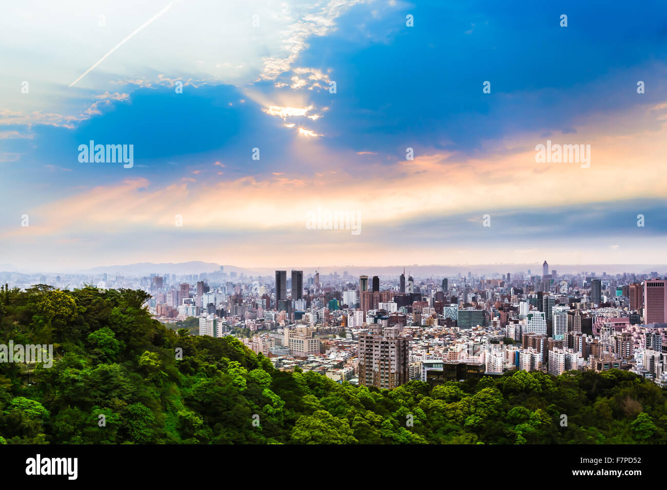 Cloudy twilight sky at an spring evening with sunshine rays at wide cityscape outskirts of Taipei, Taiwan Stock Photo