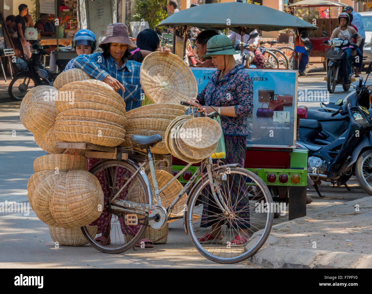 Mobile basket seller on bicycle showing off his goods to potential customers in Siem Reap Cambodia Stock Photo