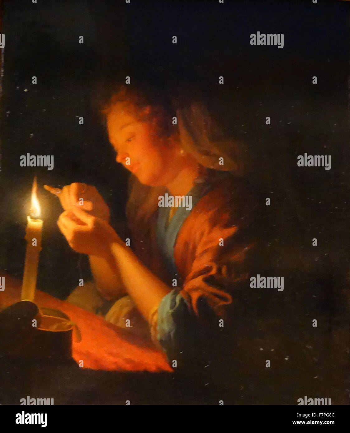 A Girl Threading a Needle by Candlelight by G. Schalcken (1643-1706). From the Dutch School. Stock Photo