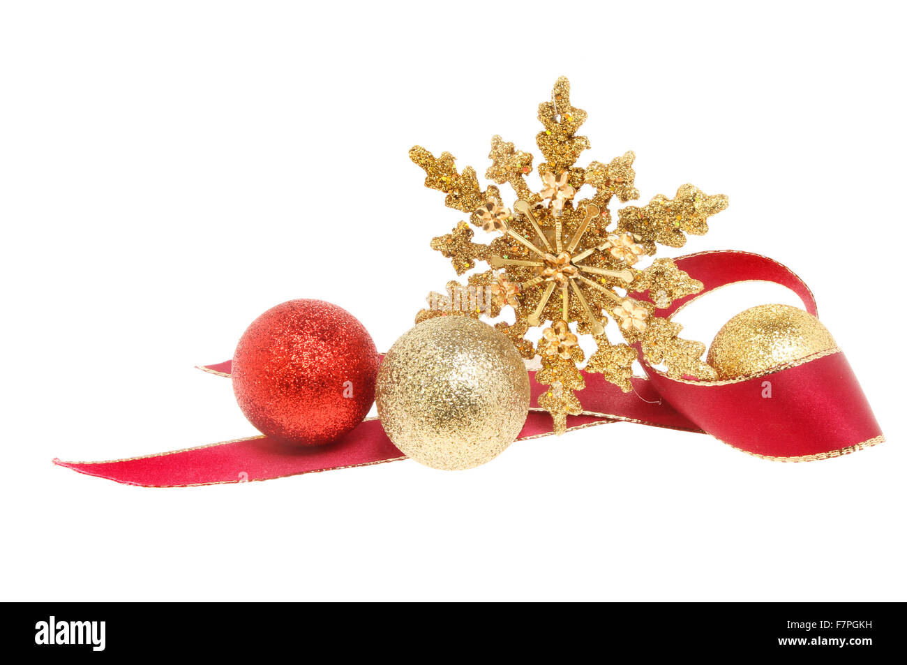 Christmas decoration a gold glitter star with red ribbon and baubles isolated against white Stock Photo