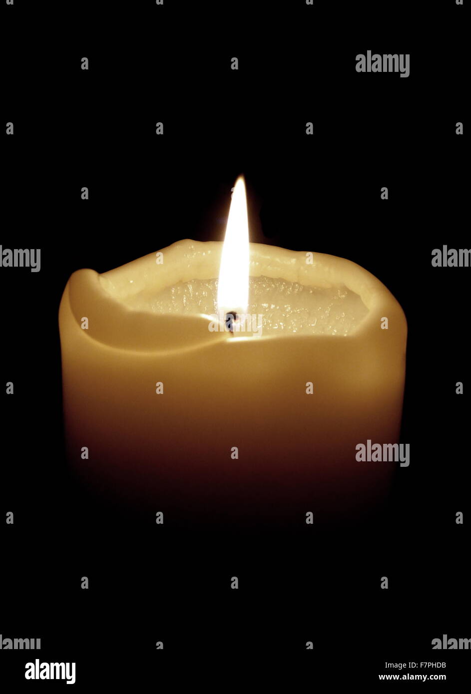 Single candle with flame used in a church Stock Photo