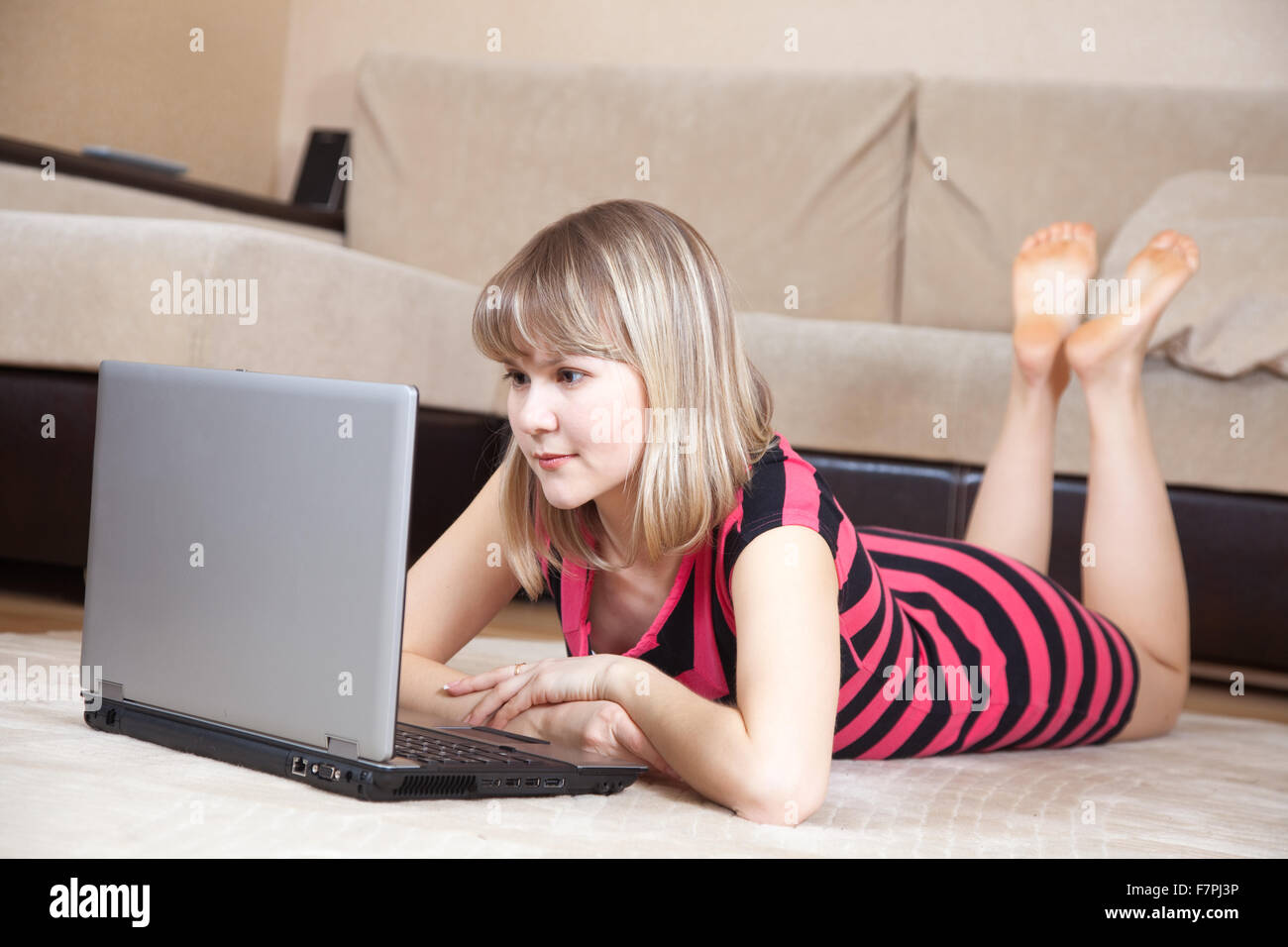 young girl lying on floor and using laptop Stock Photo - Alamy