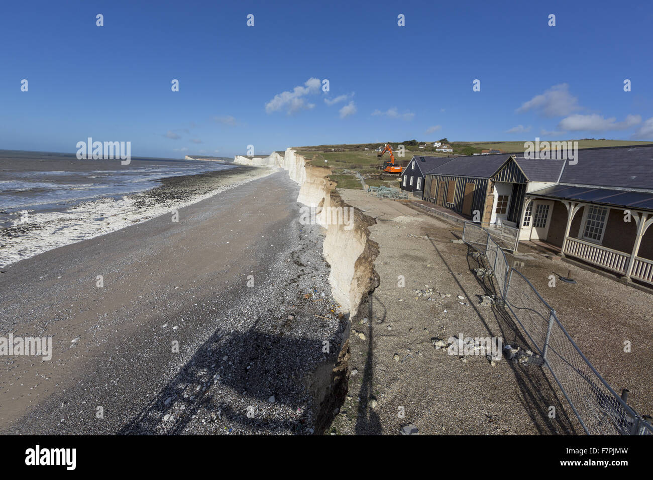 View of the storm-damaged cliffs and beach at Birling Gap, East Sussex, pictured here in February 2014, with demolition work seen taking place on vulnerable clifftop buildings. Extreme weather in January and February of that year resulted in seven years' Stock Photo