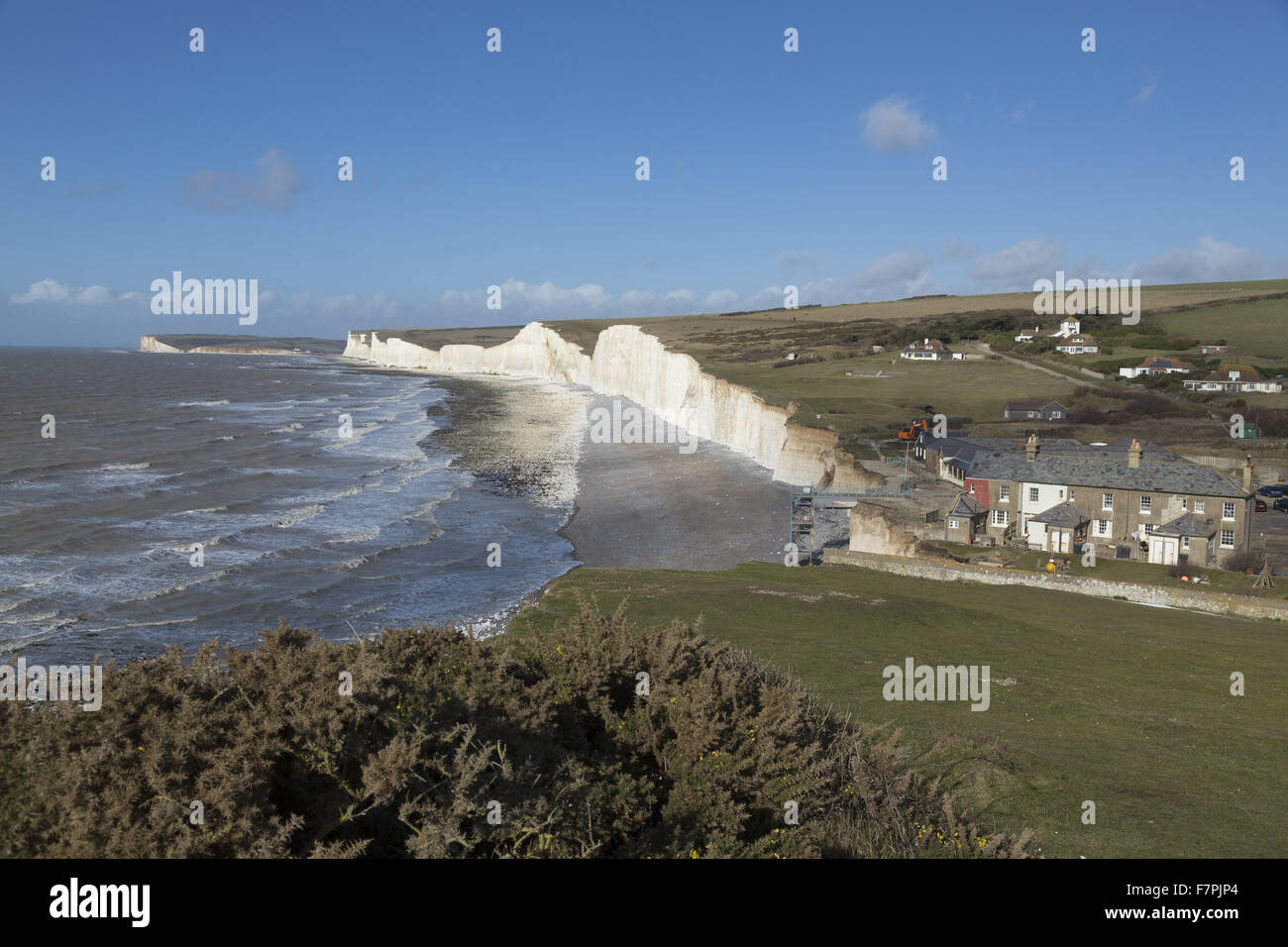 View of the storm-damaged cliffs and beach at Birling Gap, East Sussex, pictured here in February 2014, with demolition work seen taking place on vulnerable clifftop buildings. Extreme weather in January and February of that year resulted in seven years' Stock Photo