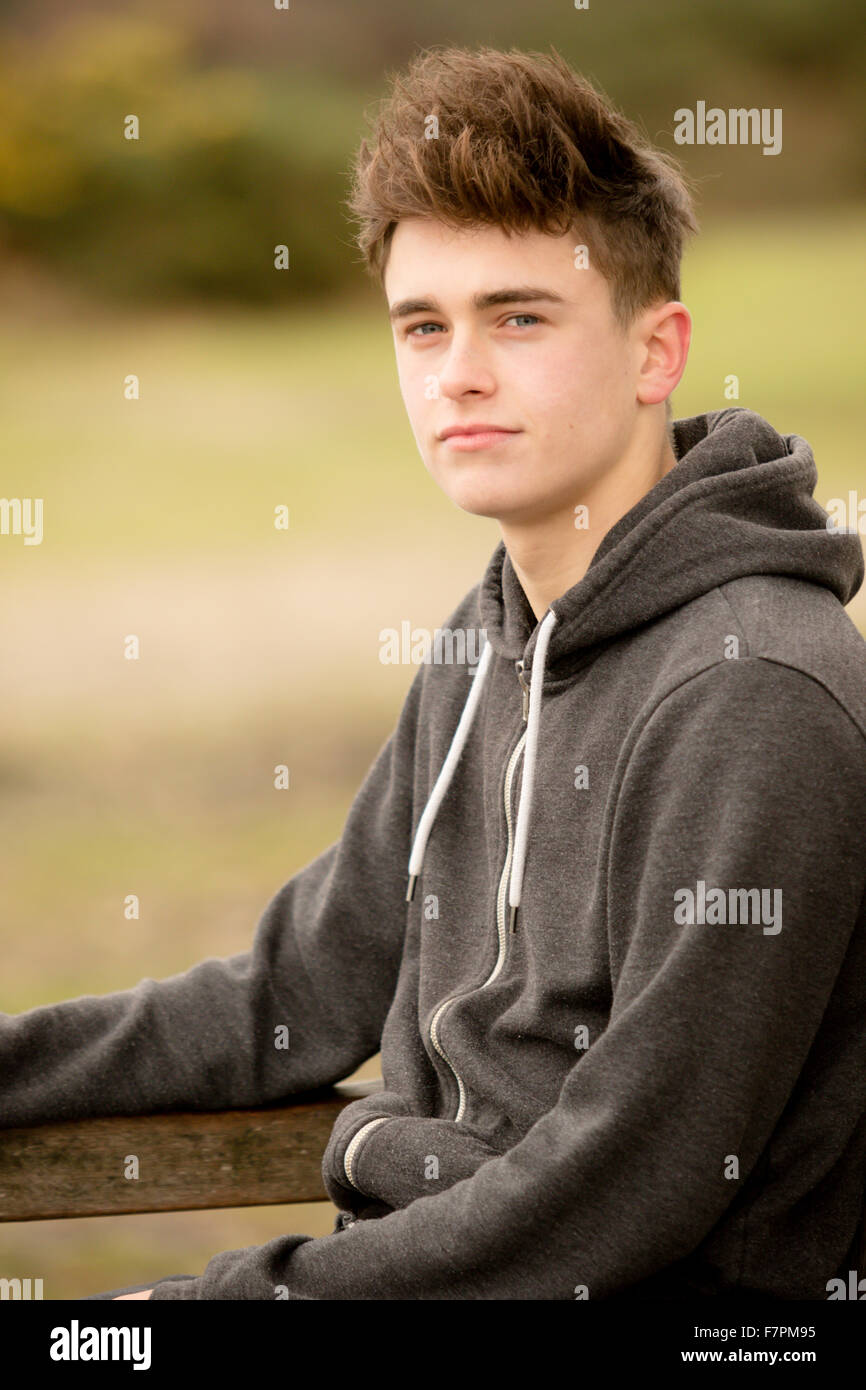 Teenage boy sitting on a park bench Stock Photo - Alamy