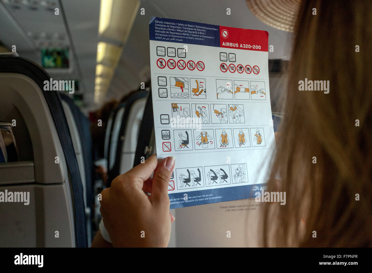Safety on board, Woman reads the safety onboard instruction card.  Airbus A320. Stock Photo