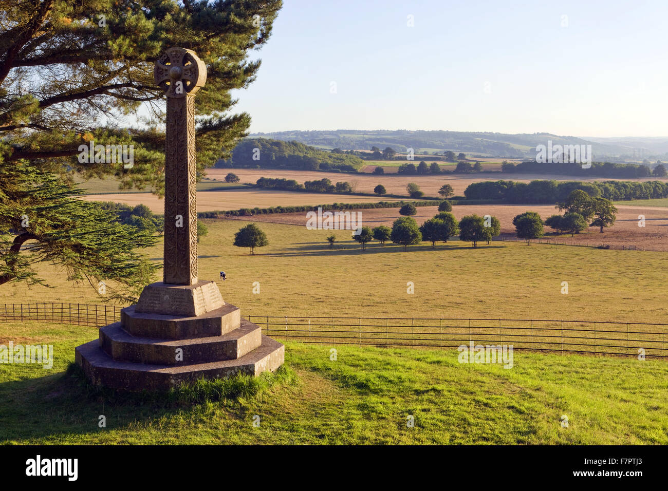 The Acland Memorial Cross, in the grounds of Killerton, Devon, with fields and Dartmoor seen beyond. The cross was erected in 1873, in memory of Sir Thomas Dycke Acland, 11th Bt. Stock Photo