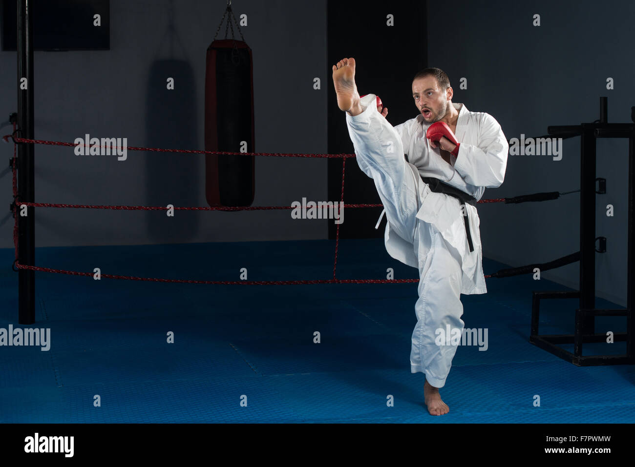 Young Man Practicing His Karate Moves - White Kimono - Black Belt Stock Photo