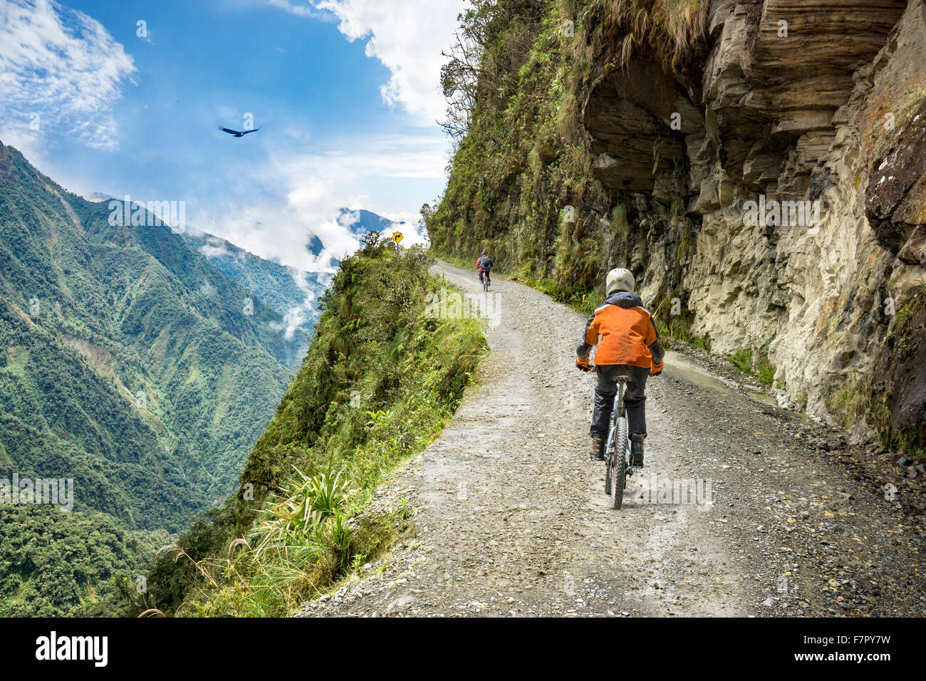 Bike adventure travel photo. Bike tourists  ride on the 'road of death'  downhill track  in Bolivia. Stock Photo