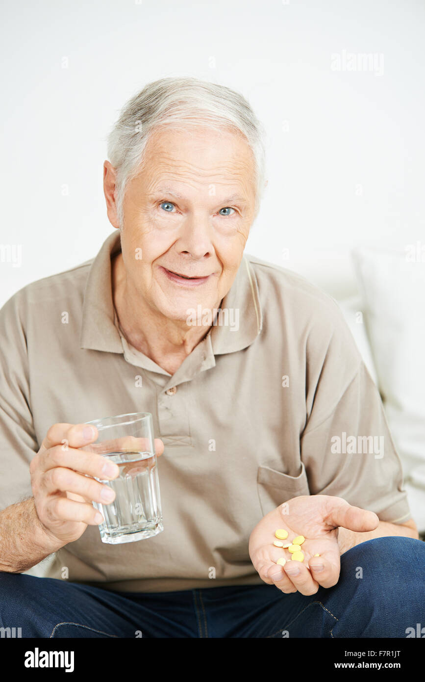 Senior man taking medicine with a glass of water Stock Photo Alamy