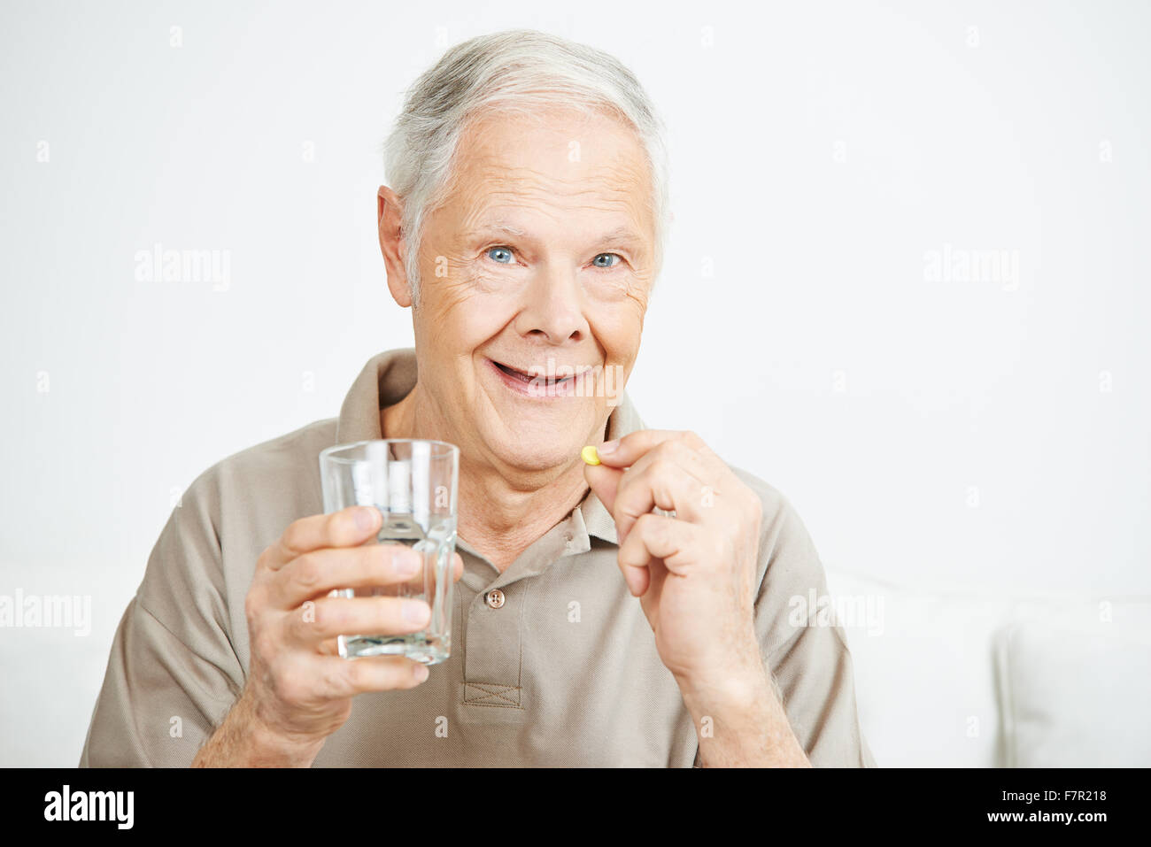 Old man swallowing a pill with a glass of water Stock Photo Alamy