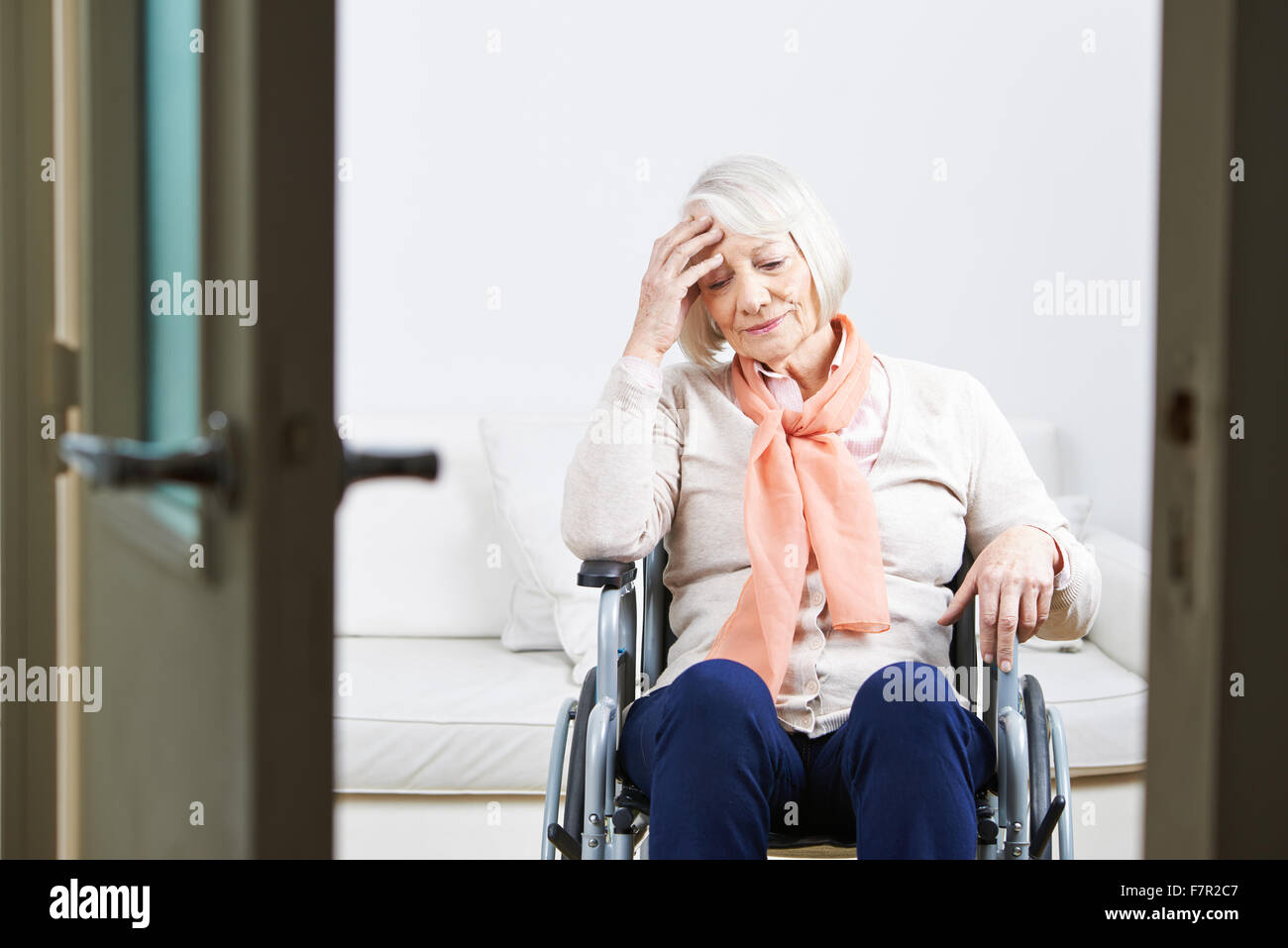 Old lonely woman in wheelchair at home looking sad Stock Photo