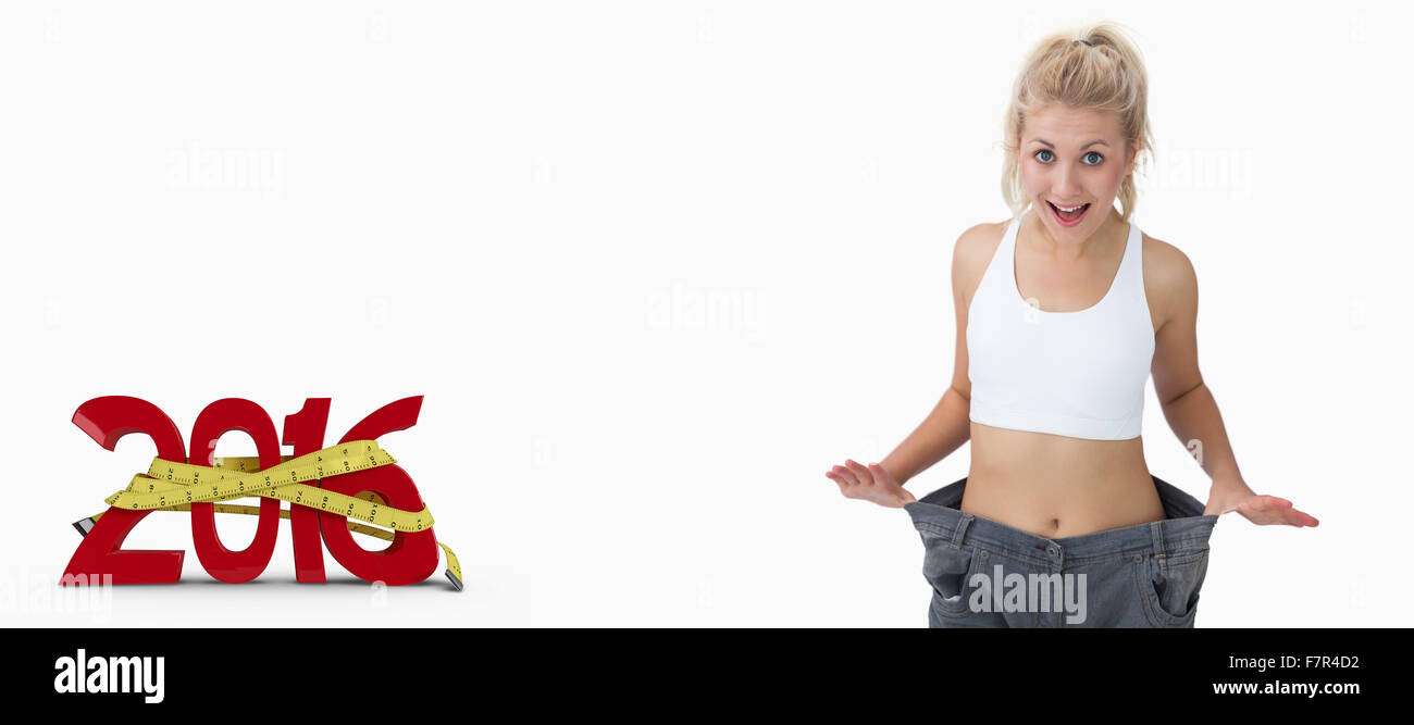 Composite image of thin woman wearing old pants after losing weight Stock Photo