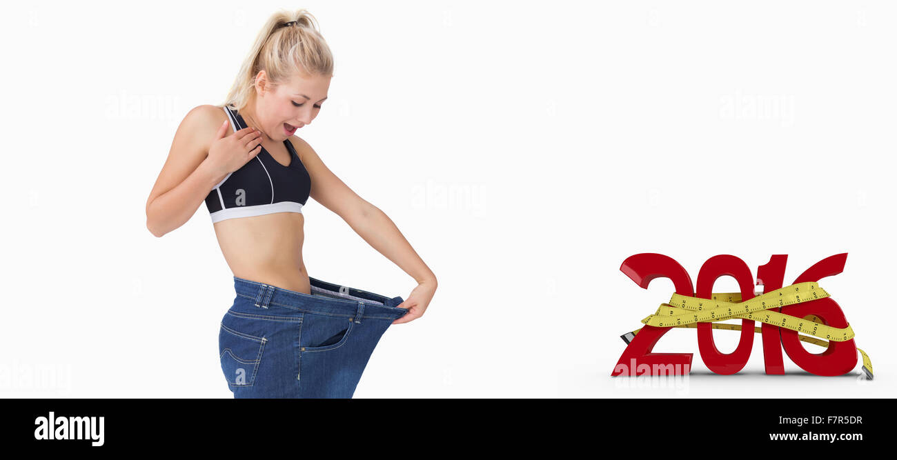 Composite image of young thin woman wearing old pants after losing weight Stock Photo