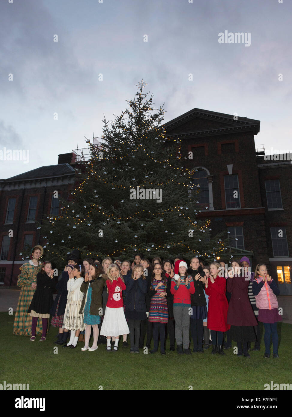 London, UK. 2 December 2015. Children from St Mary Abbots School sing carols outside the east front of Kensington Palace as the 25ft Christmas tree is switched on. Kensington Palace celebrates a Victorian Christmas with special decorations. Credit:  Vibrant Pictures/Alamy Live News Stock Photo
