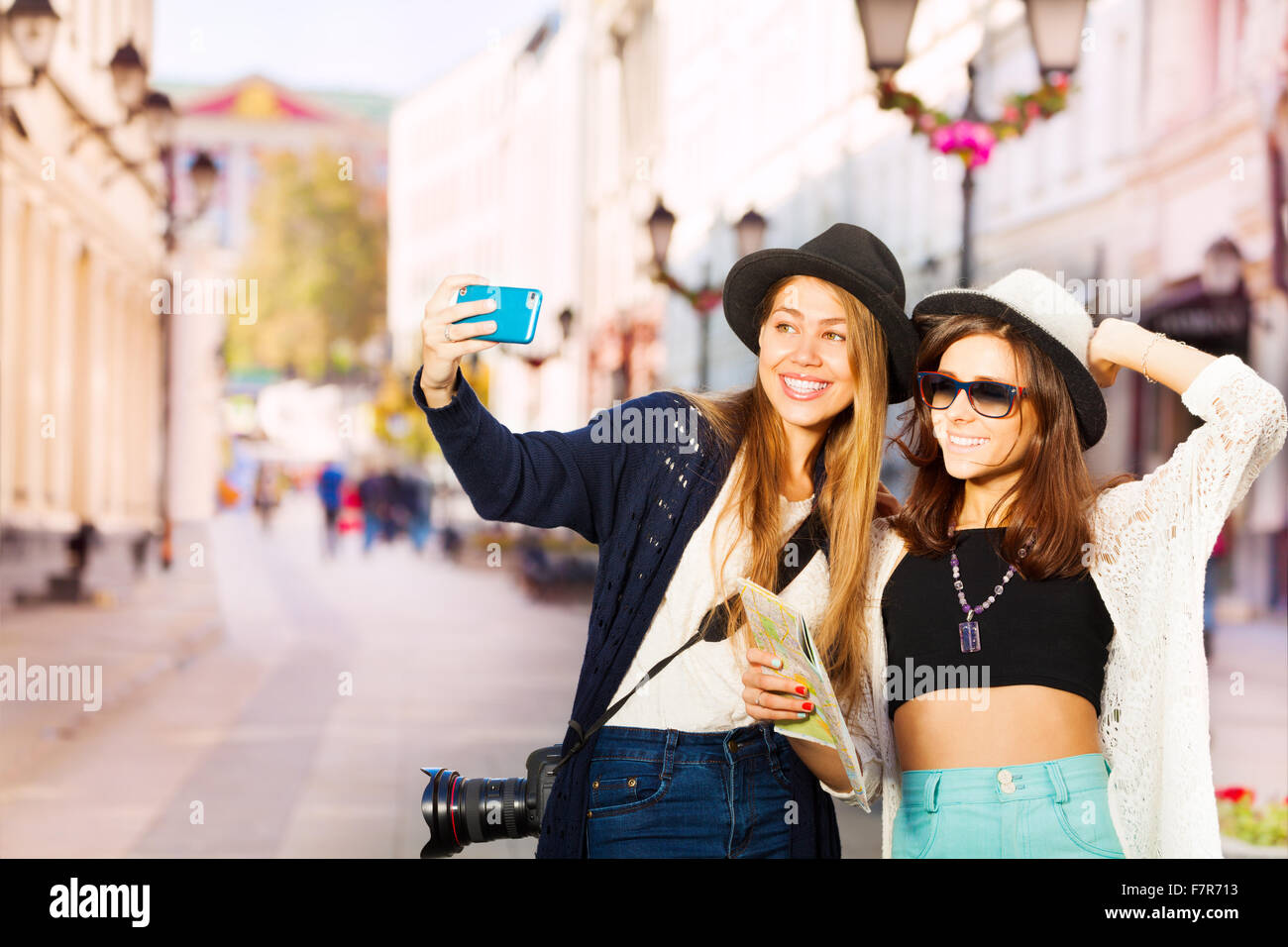 Two happy girls taking selfies with mobile phone Stock Photo
