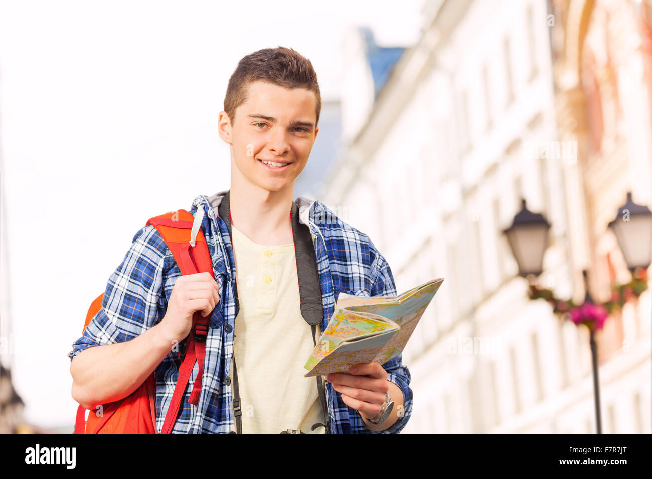 Boy with rucksack and city map on the street Stock Photo
