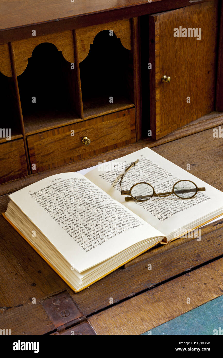 Book and spectacles in a bureau in the Main Bedroom at Eyam Hall and Craft Centre, Derbyshire. Eyam Hall is an unspoilt example of a gritstone Jacobean manor house, set within a walled garden. Stock Photo