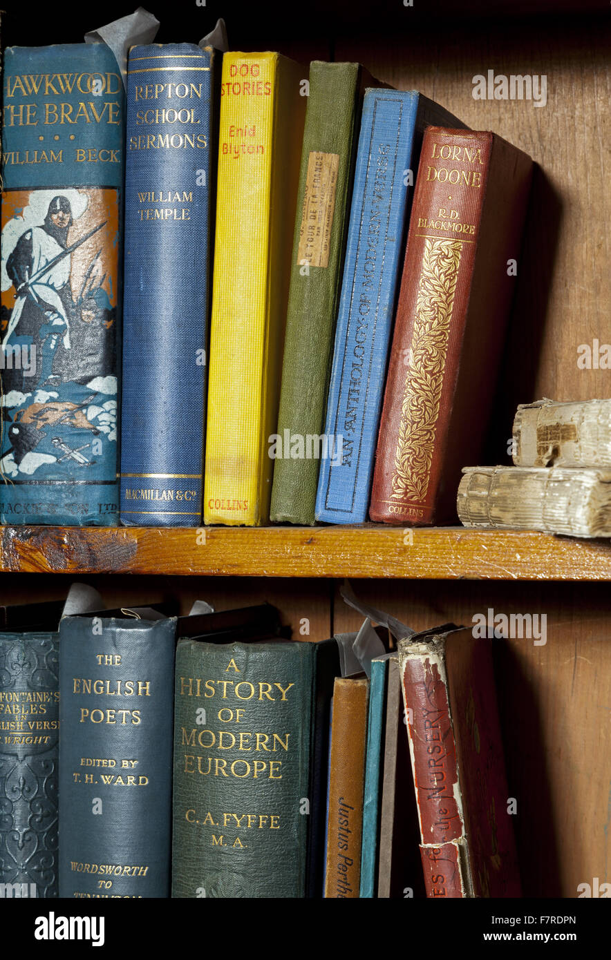 Books on shelves in the Nursery at Eyam Hall and Craft Centre, Derbyshire. Eyam Hall is an unspoilt example of a gritstone Jacobean manor house, set within a walled garden. Stock Photo