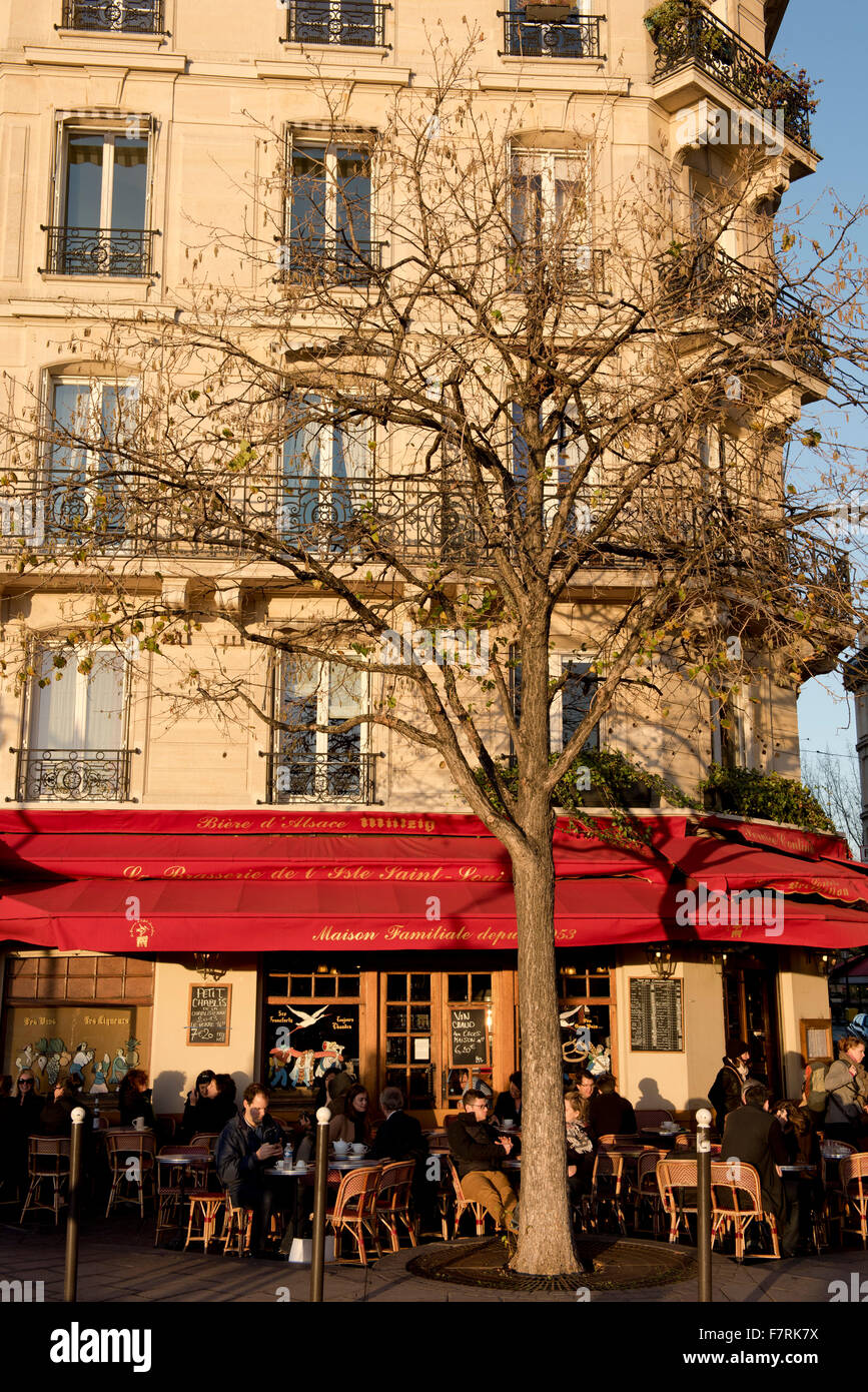 People sitting at pavement tables at a busy cafe on the Ile St Louis; Paris, France Stock Photo