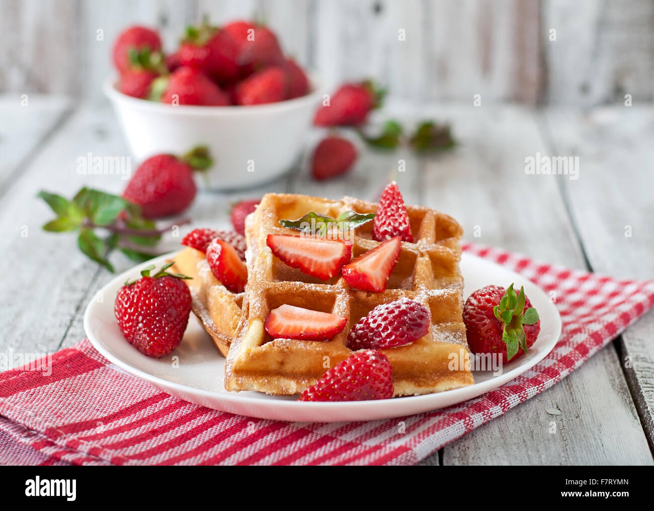 Belgium waffles with strawberries and mint on white plate. Stock Photo
