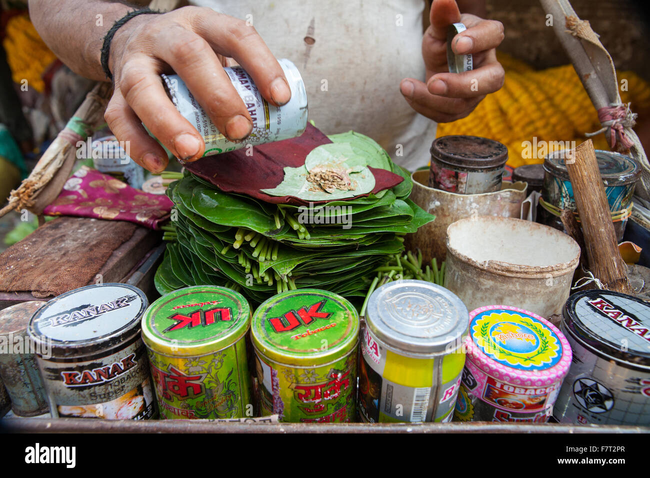 Detail of a paan vendor preparing a mixture of tobacco and areca nut on a betel leaf, in Calcutta Stock Photo