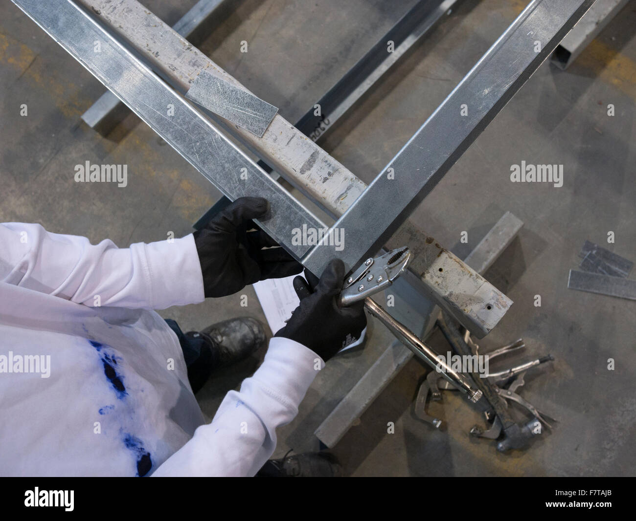 Worker binding metal frames with clamps for welding Stock Photo Alamy