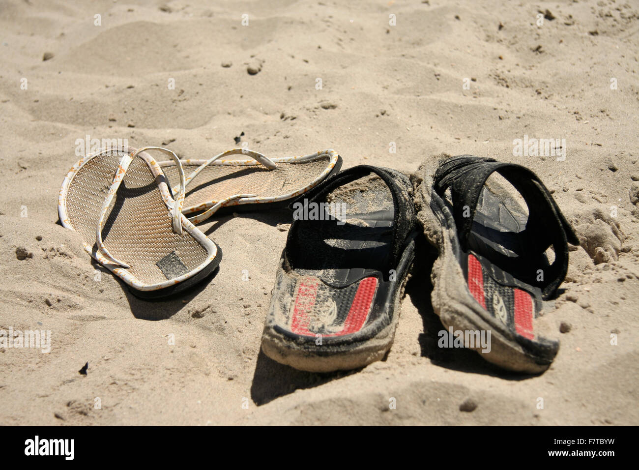 Male and female sandals standing on the sand, Algeciras, Spain Stock Photo