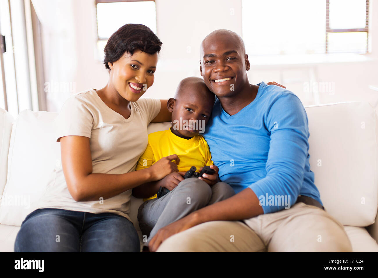 happy African American family sitting on the couch at home Stock Photo ...