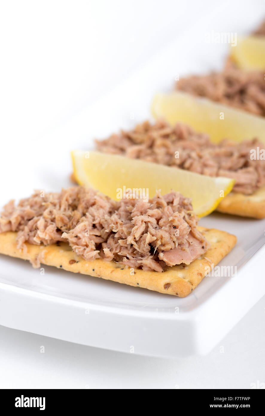 Tuna meat on crackers as snack or appetizer over white background Stock Photo Alamy
