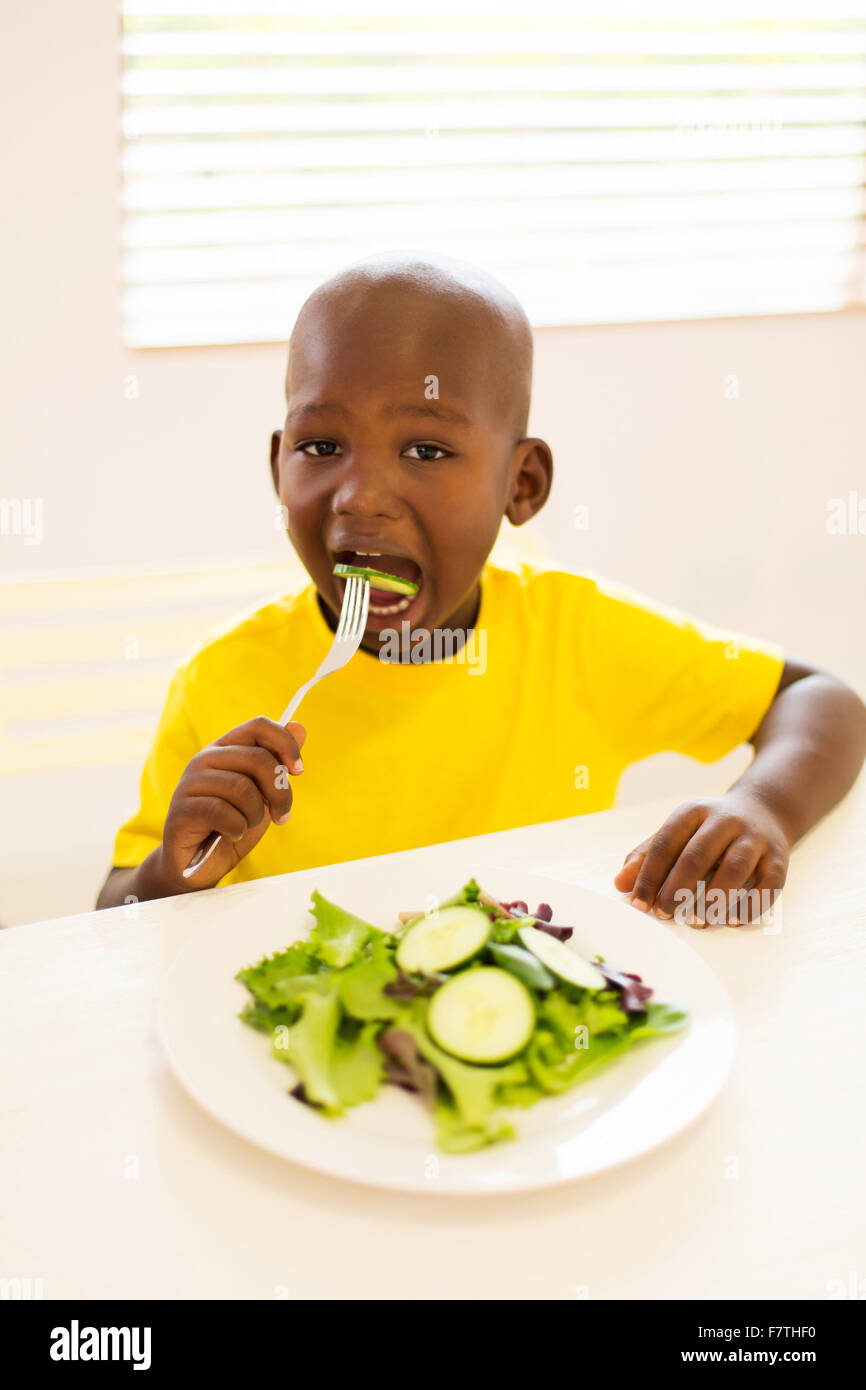 adorable little boy eating salad at home Stock Photo