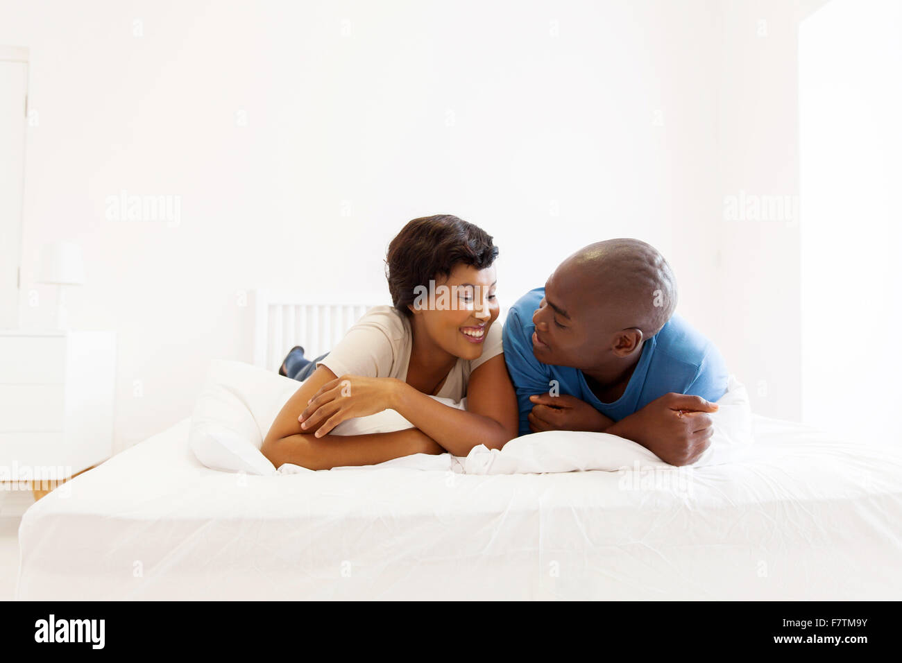 Lovely African American Couple Lying On Bed Stock Photo