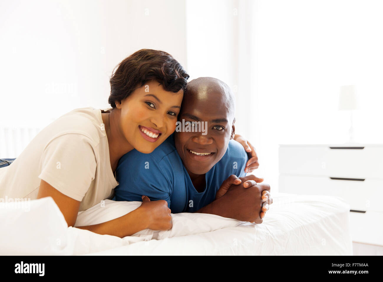 beautiful young African married couple lying on bed Stock Photo - Alamy